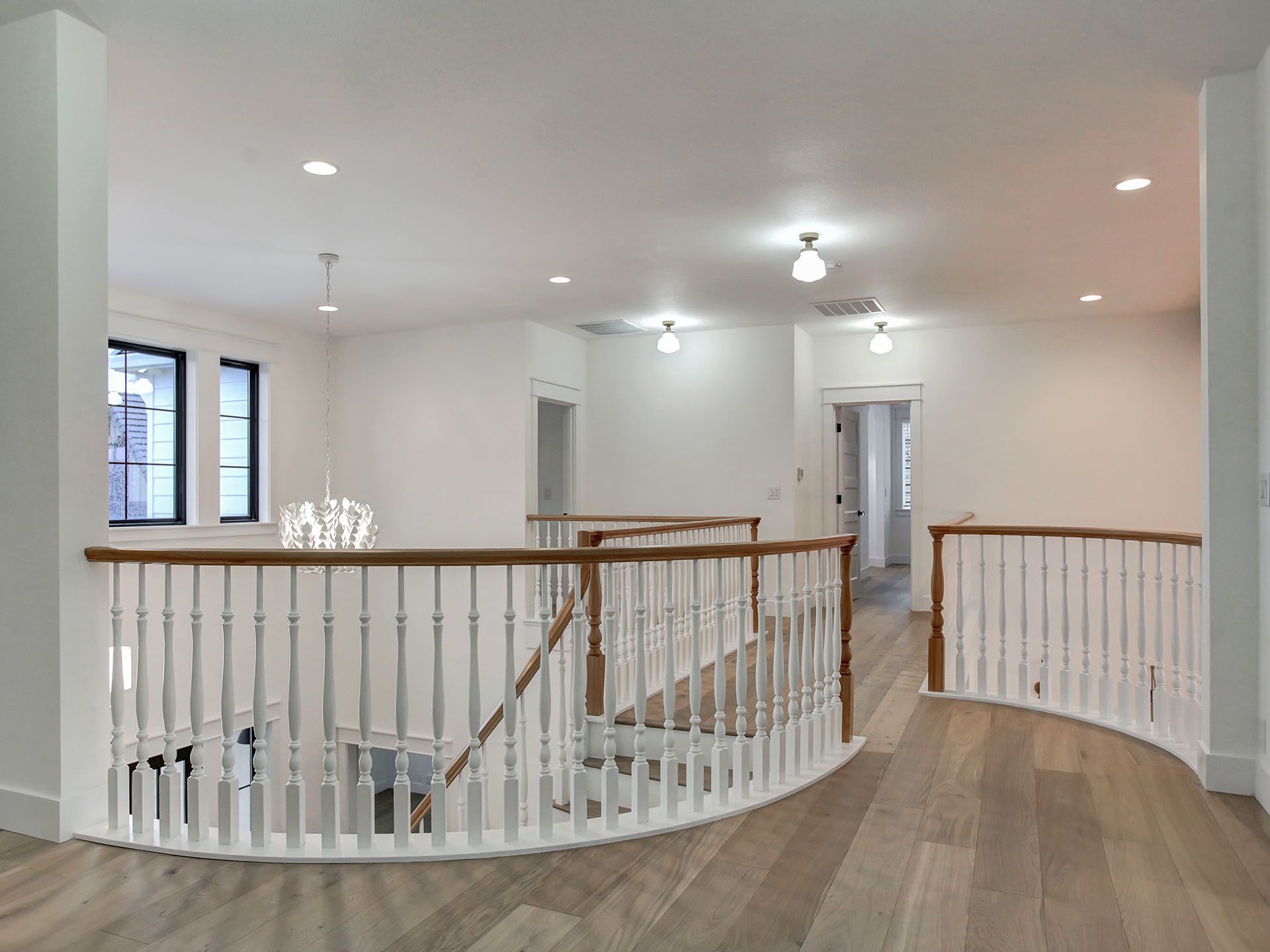 A curved staircase in a house with white railings