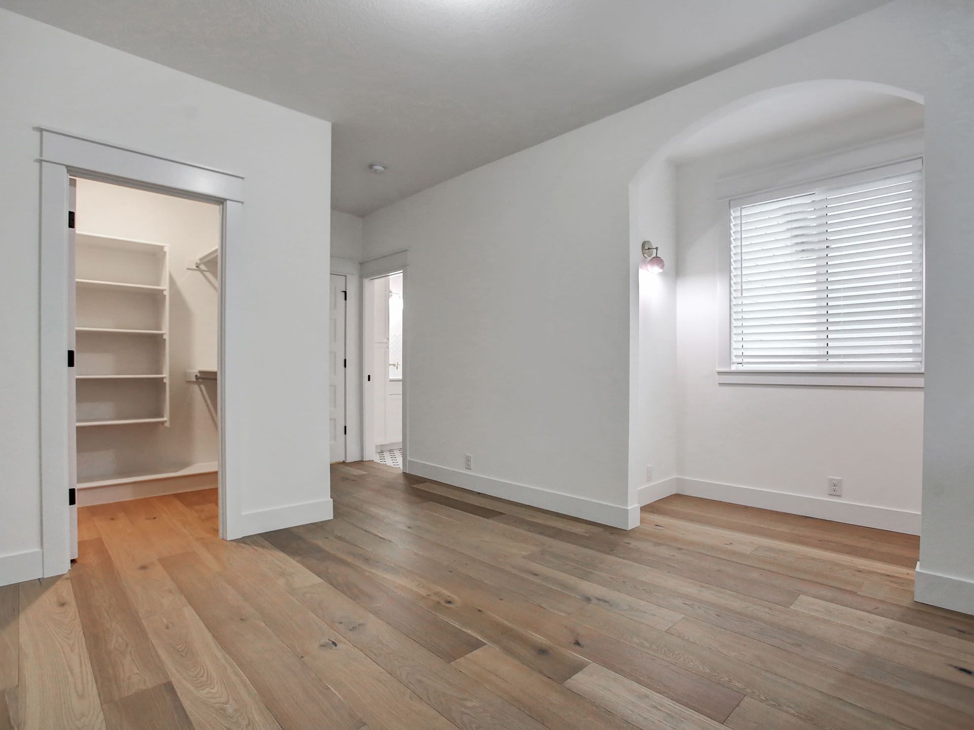An empty room with hardwood floors and a walk in closet
