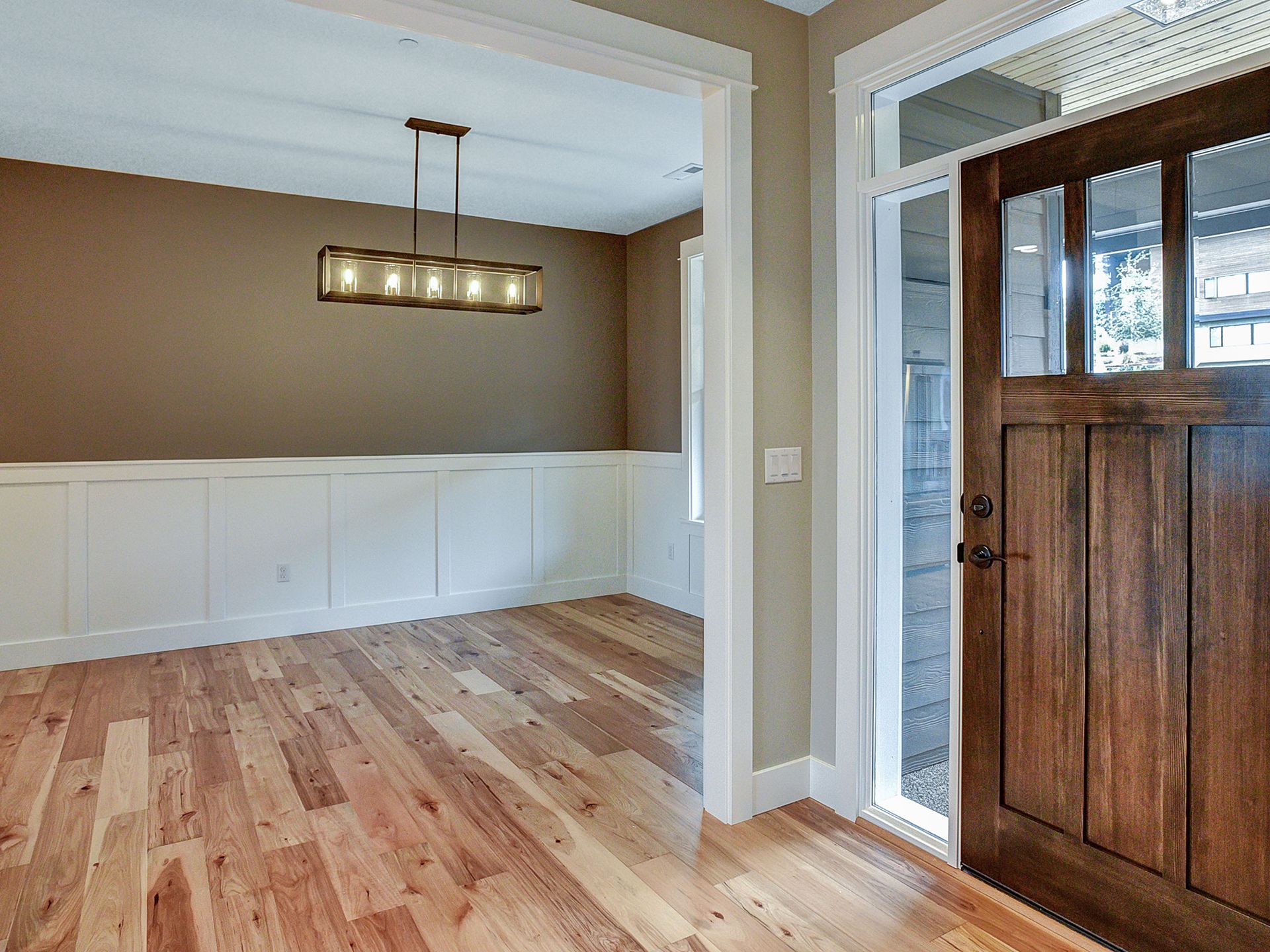 An empty room with hardwood floors and a wooden door