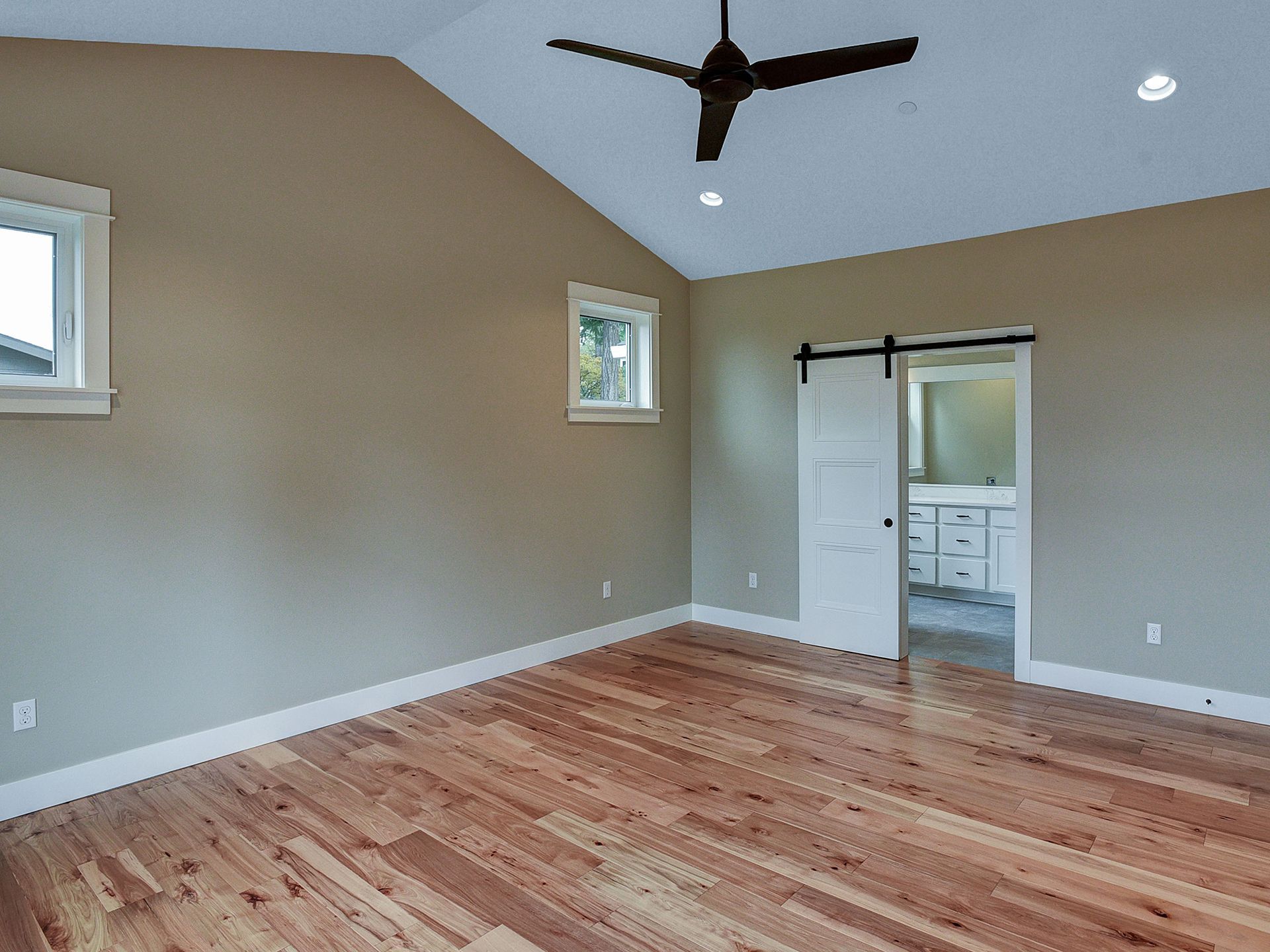 An empty room with hardwood floors and brown wall paint