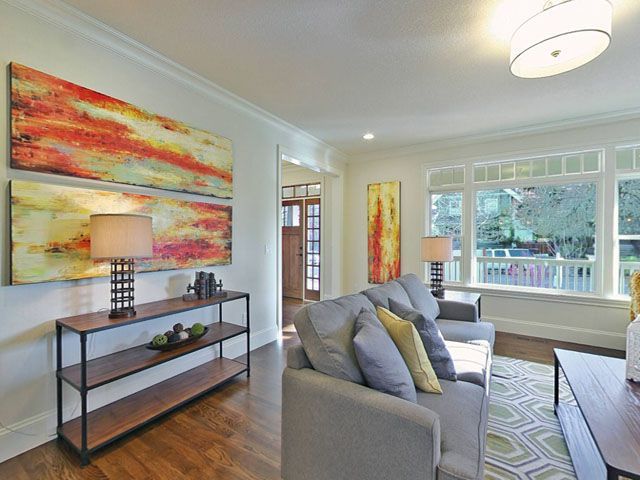 A living room with a couch and paintings on the wall