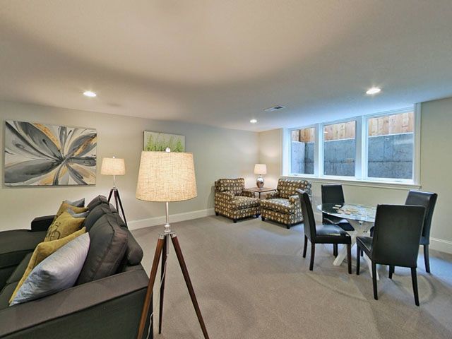 A living room with a couch, chairs, a table, and lamps