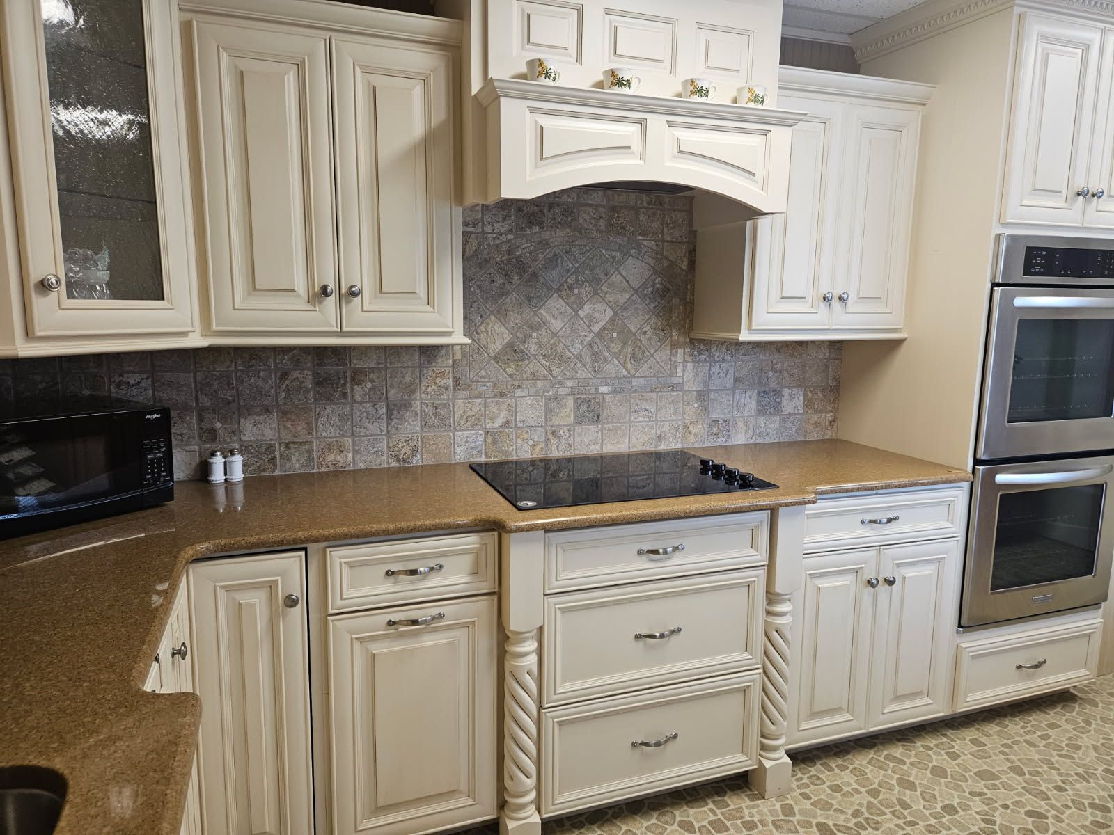 A kitchen with white cabinets and stainless steel appliances.
