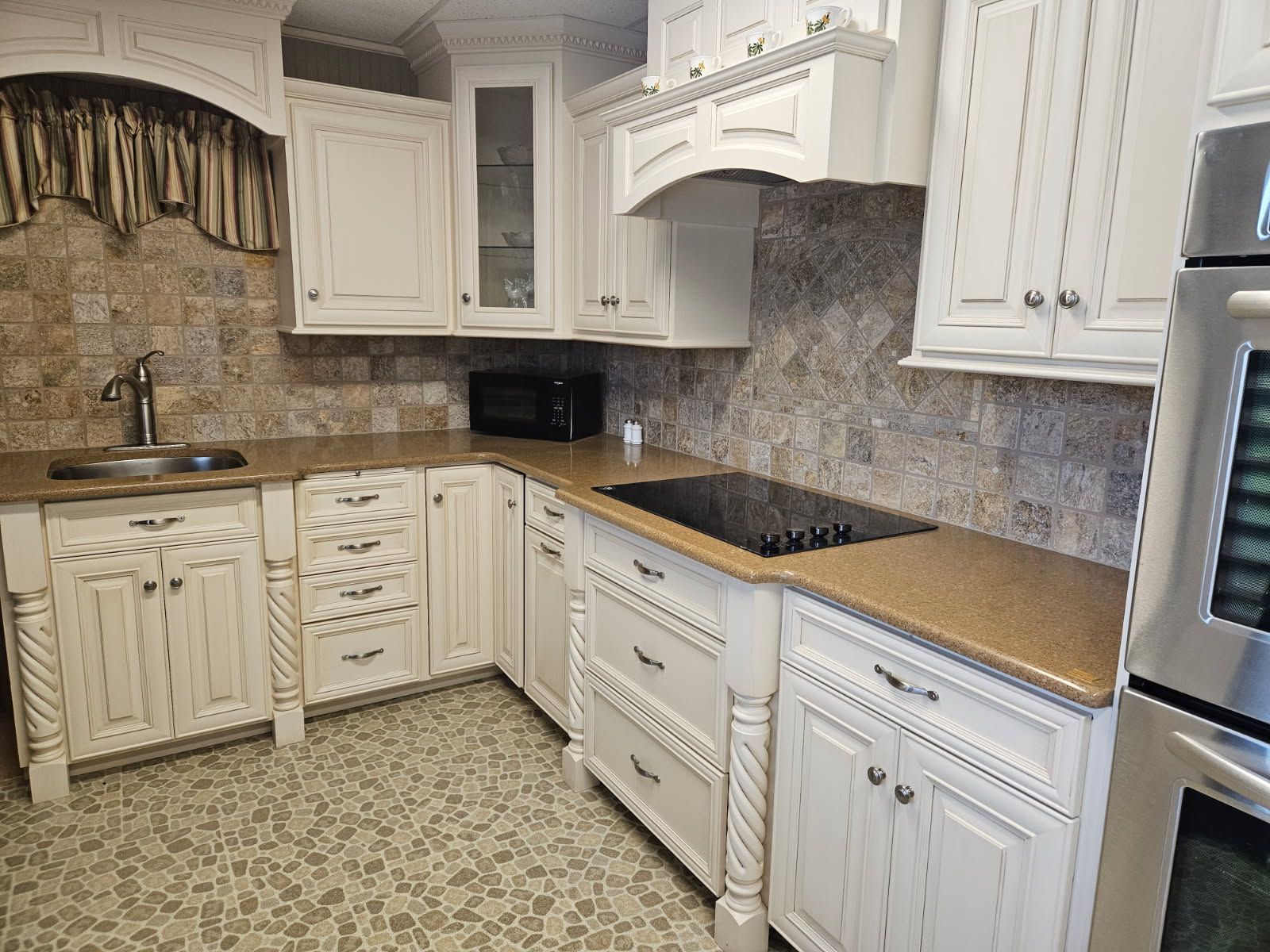 A kitchen with white cabinets and stainless steel appliances.