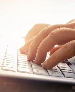 Man's hands typing on laptop keyboard
