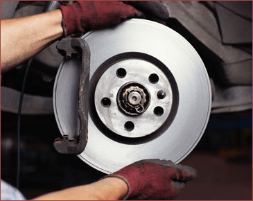 Car mechanic repairing brakes