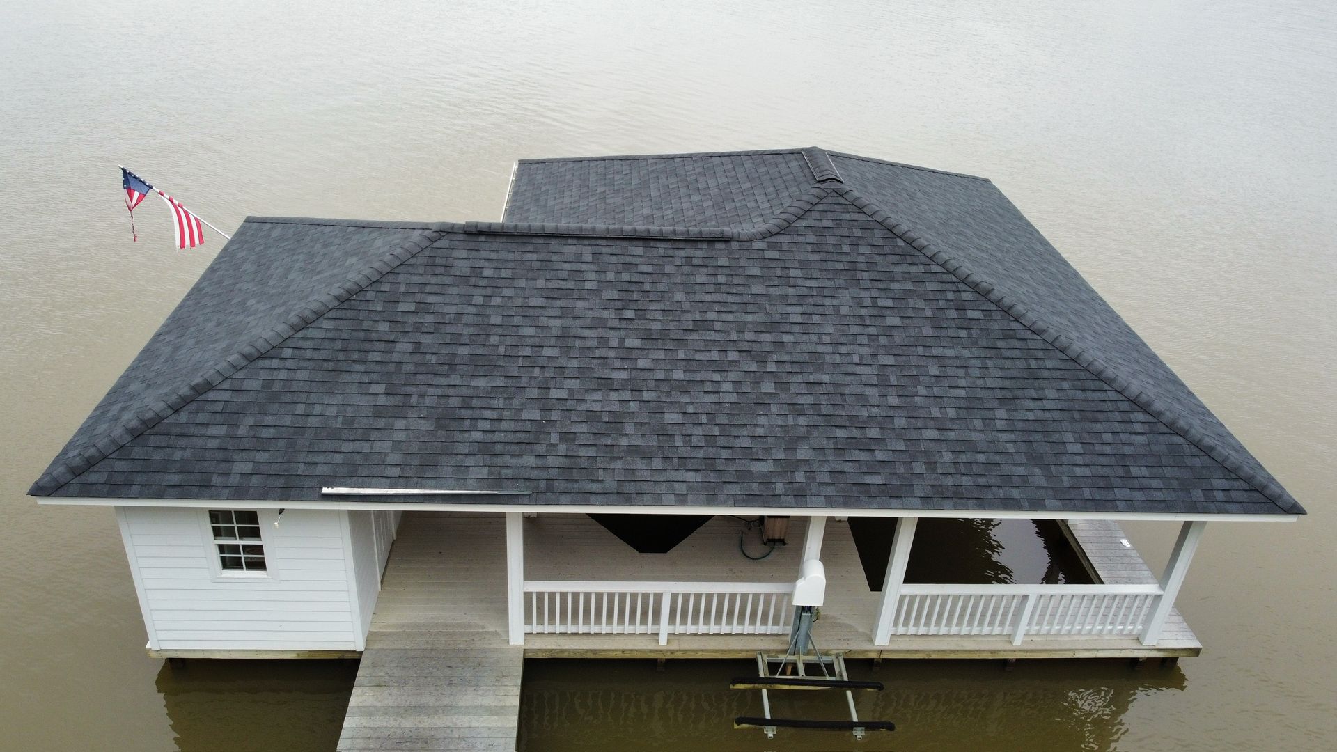 Scale model of a white house with a dark gray roof, front porch, and ramp on a plain background