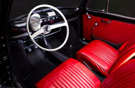 A black car with red seats and a white steering wheel