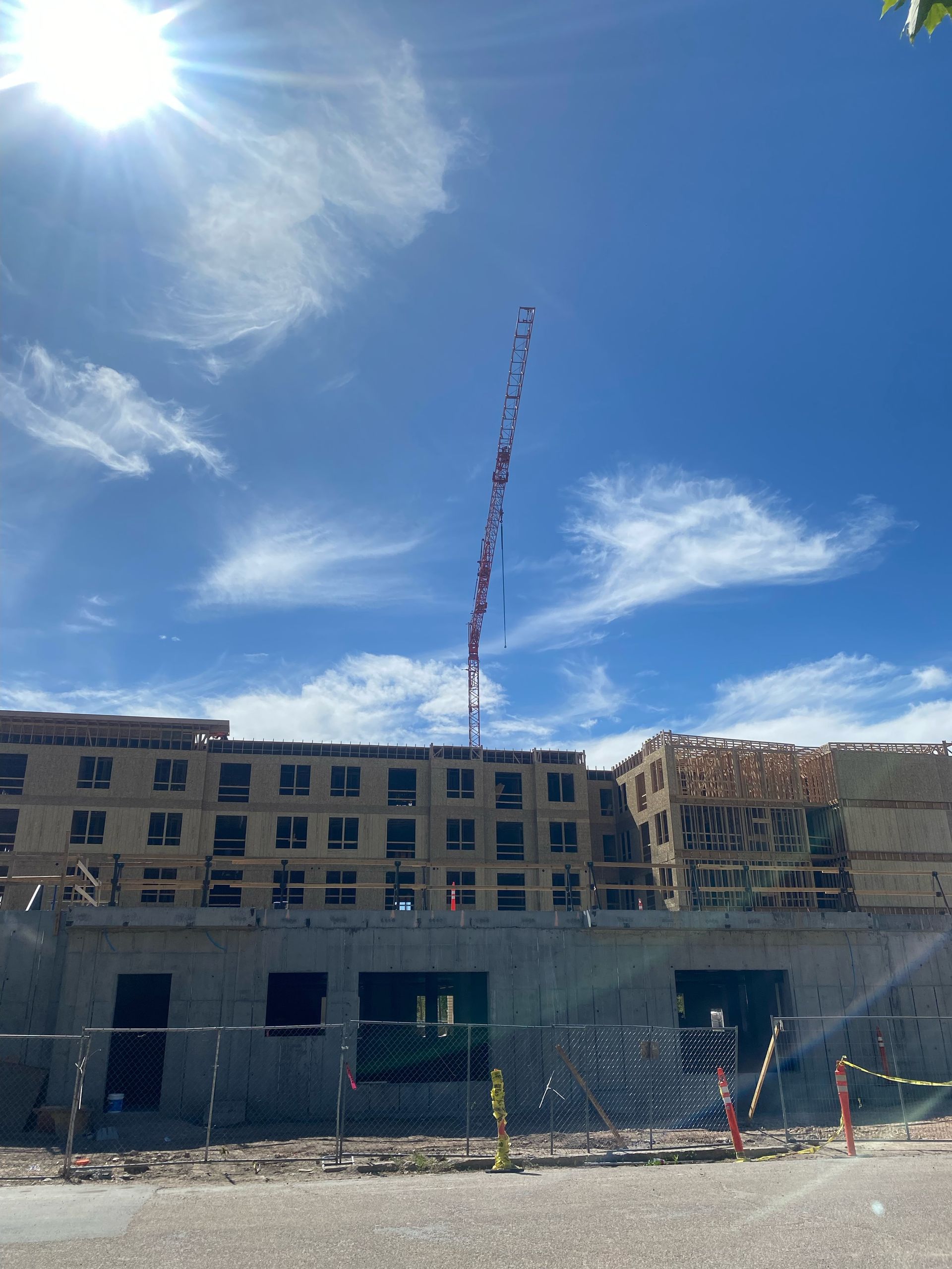 A large building under construction with a crane in the background.