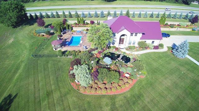 an aerial view of a house with a purple roof and a pool in the backyard .