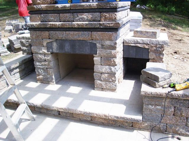 a brick fireplace is being built in a backyard