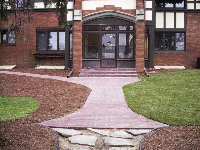 a brick building with a walkway leading to the front door