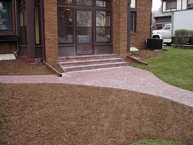 a brick walkway leading to the front door of a house