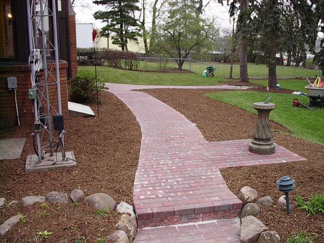 a red brick walkway leading to a house