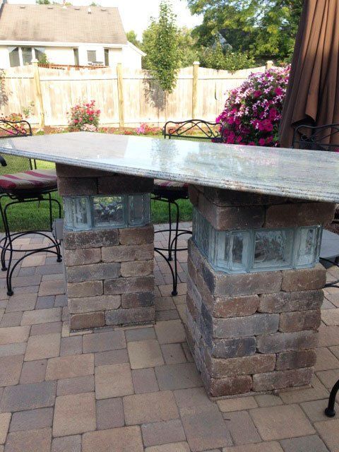 a patio with a table and chairs made out of bricks .