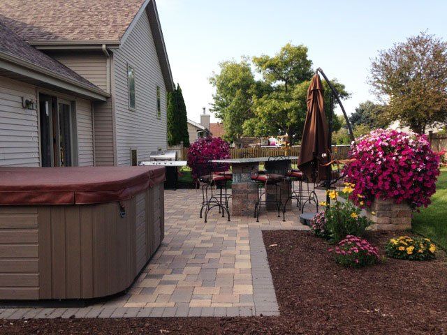 a hot tub is sitting on a patio next to a house
