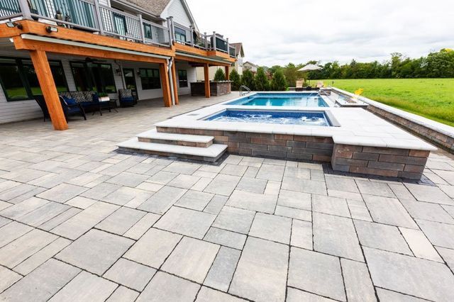 there is a large swimming pool in the backyard of a house .