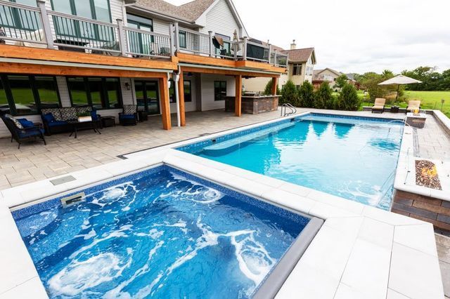 a large swimming pool with a hot tub next to it .
