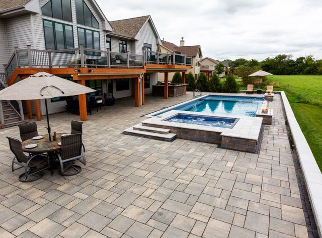 there is a large swimming pool in the backyard of a house .