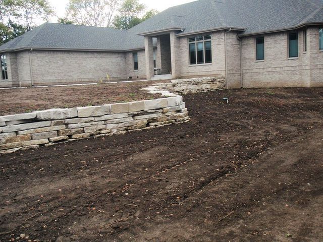 a brick house with a stone wall in front of it