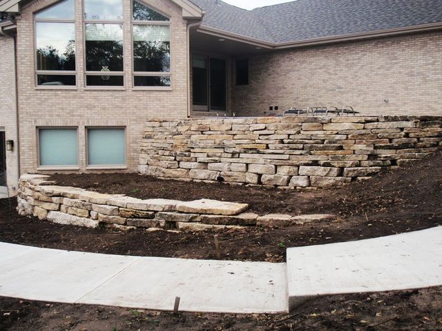 a brick house with a stone wall in front of it
