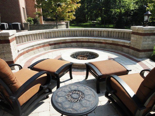 a fire pit is surrounded by chairs and ottomans
