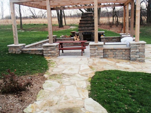 a wooden pergola with a picnic table underneath it