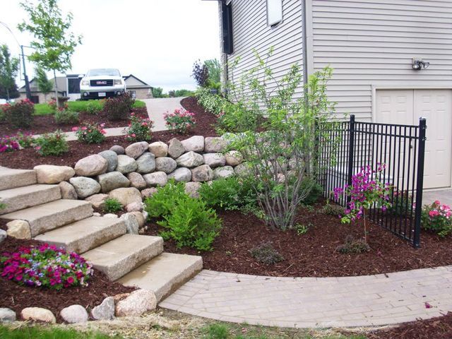 a house with stairs and flowers in front of it