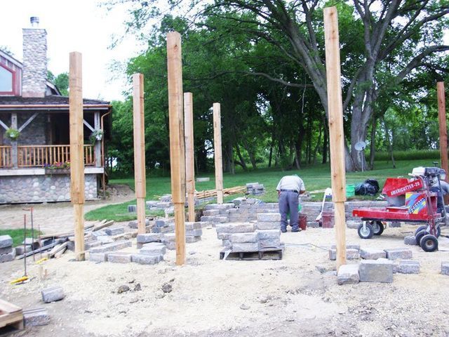 a red forklift is moving bricks in front of a house