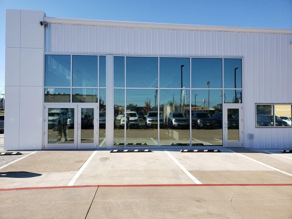 Modern commercial building with large glass windows and empty parking spaces in front