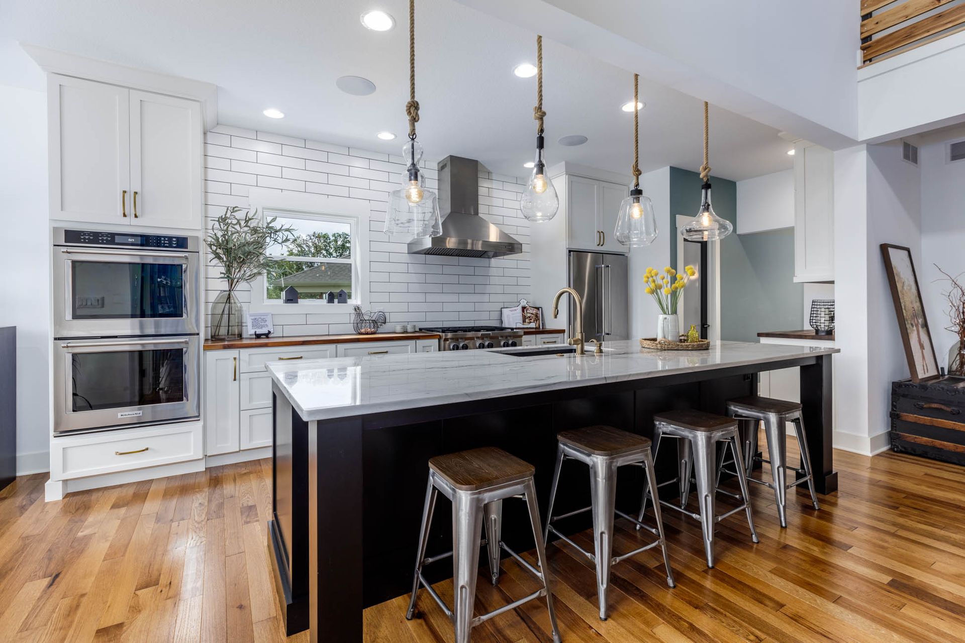 A kitchen with a large island and stools in it