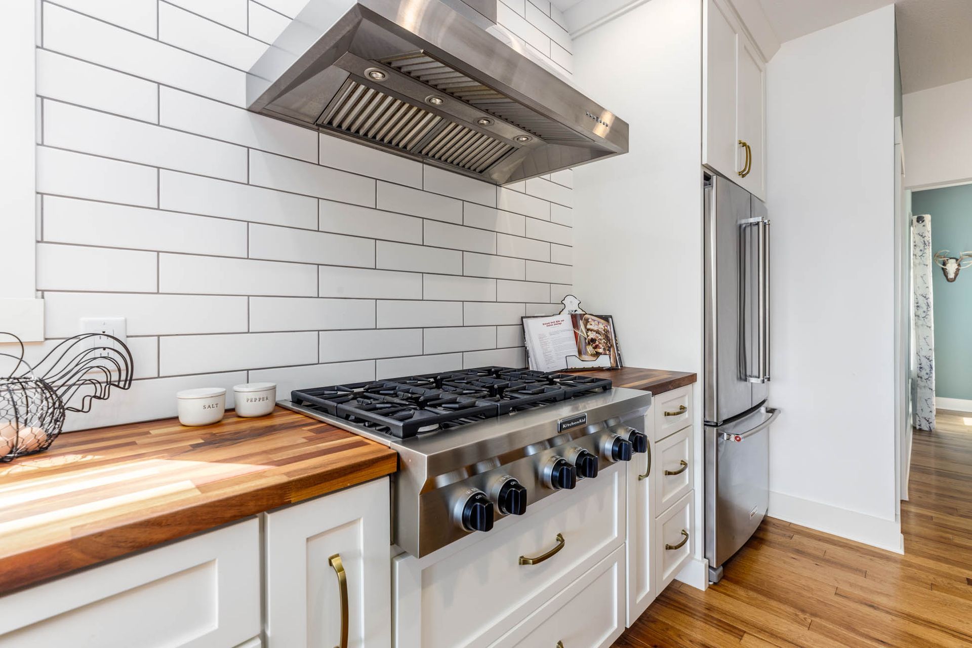 A kitchen with a stove top oven and a refrigerator