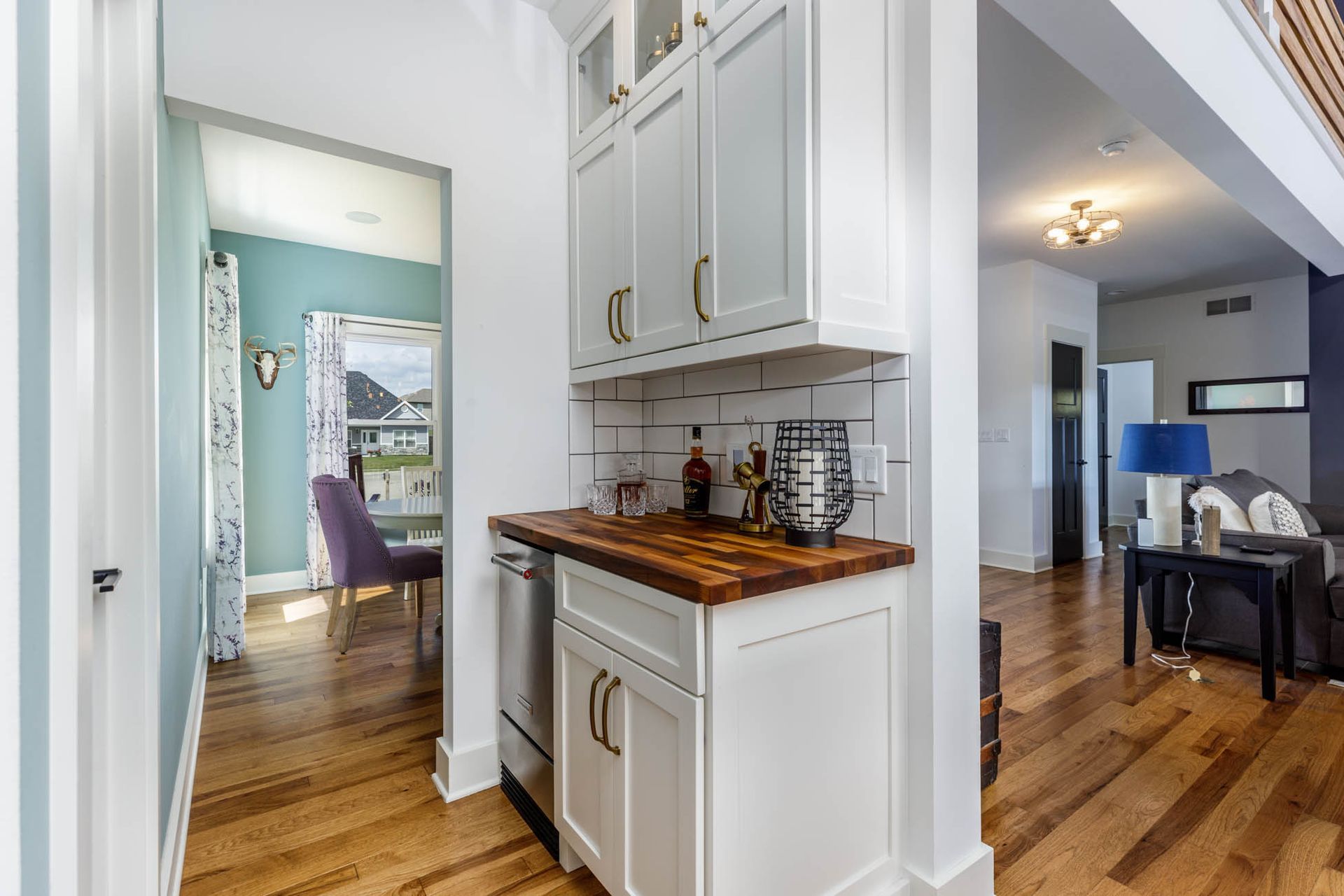 A kitchen with white cabinets and a wooden counter top