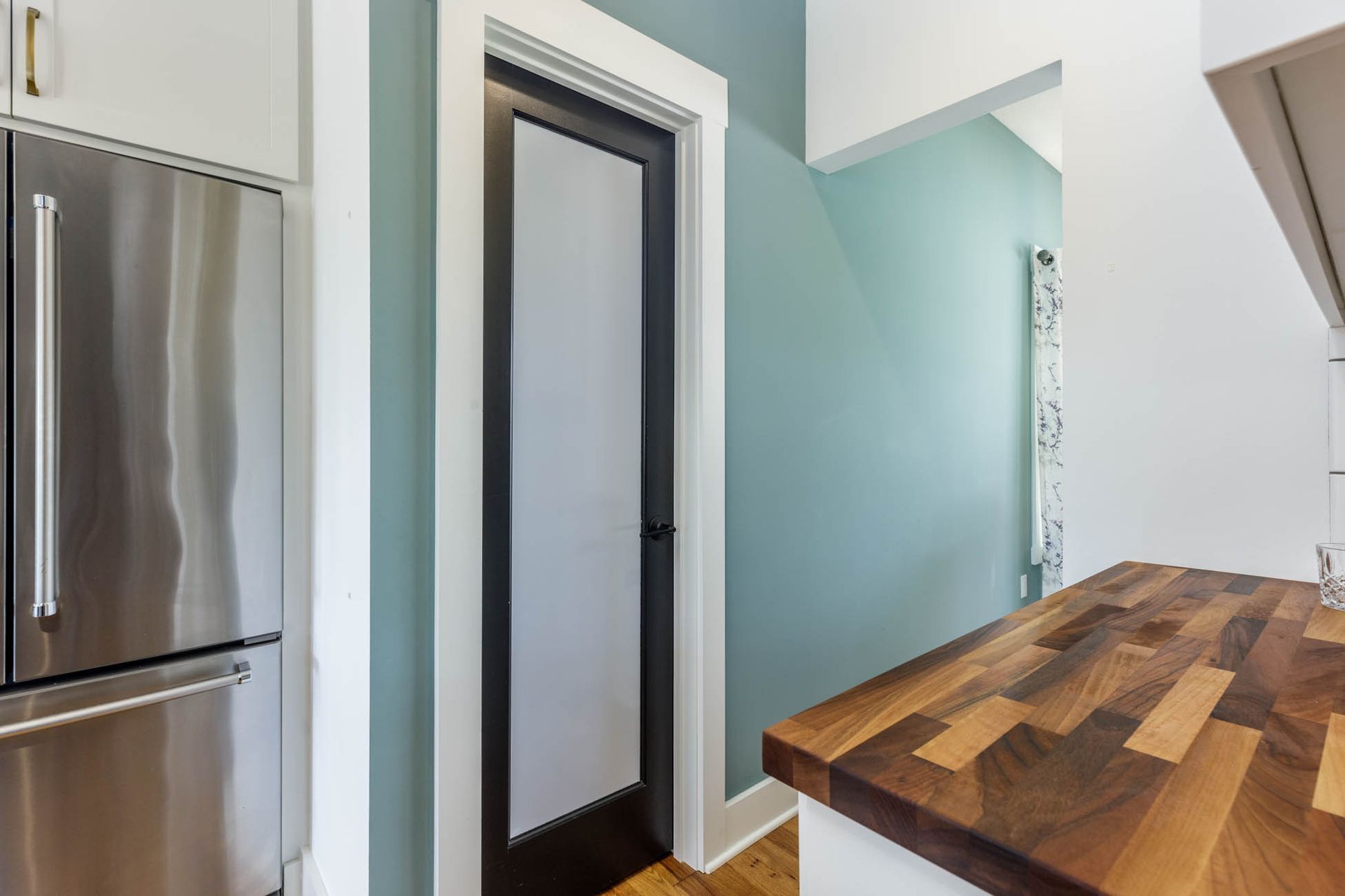 A kitchen with a stainless steel refrigerator and a wooden counter top