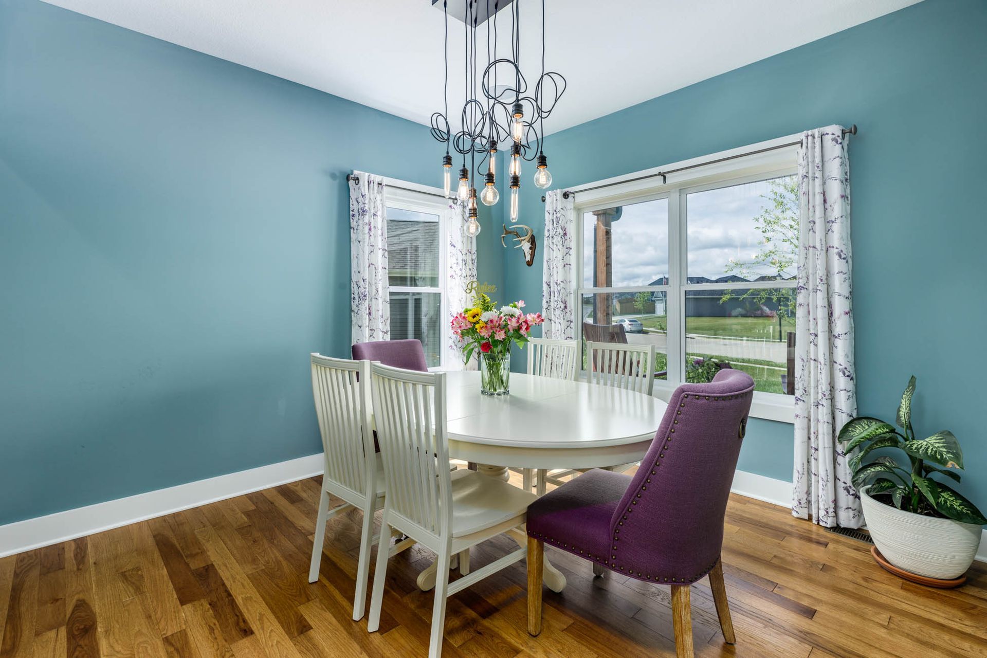 A dining room with a table and chairs and a chandelier