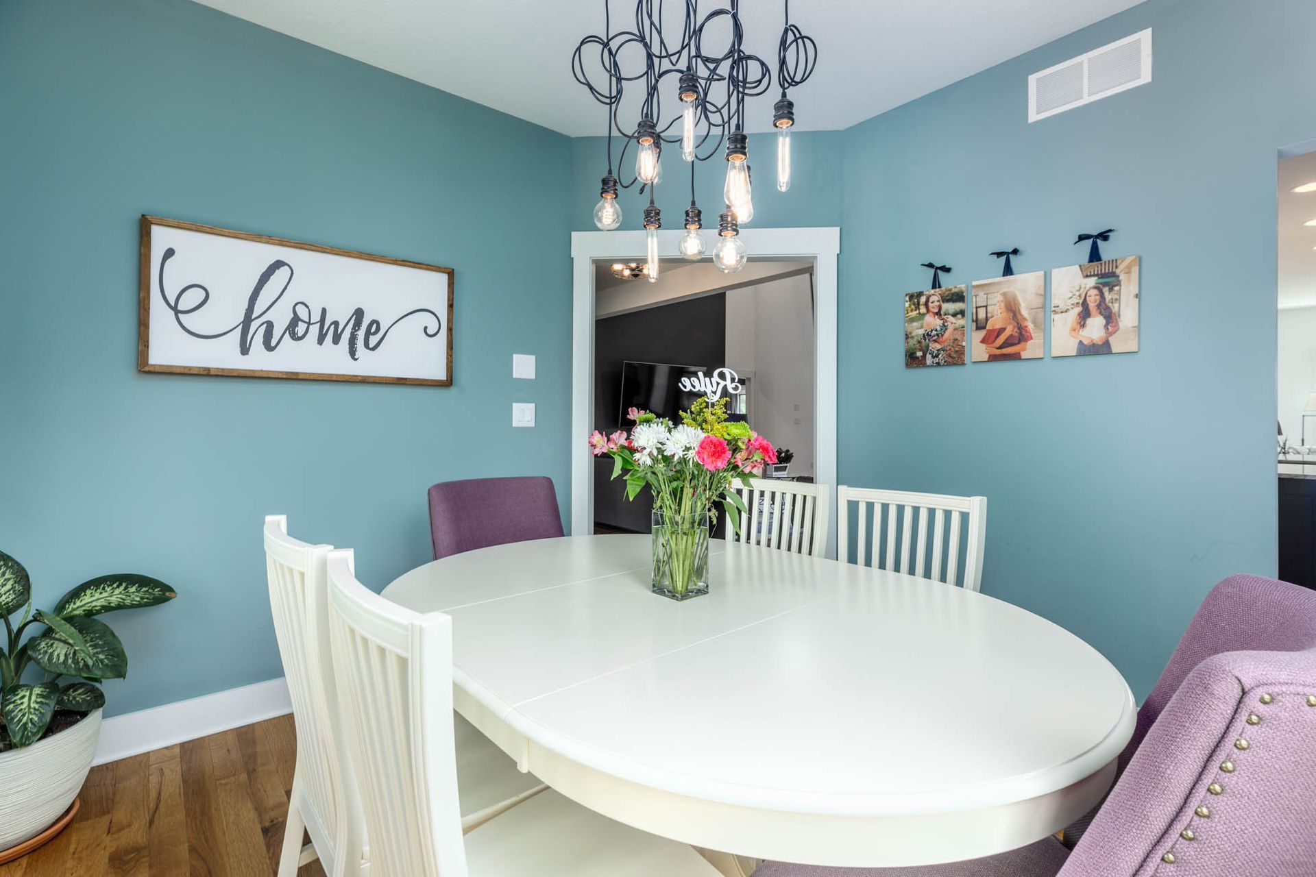 A dining room table with a vase of flowers on it