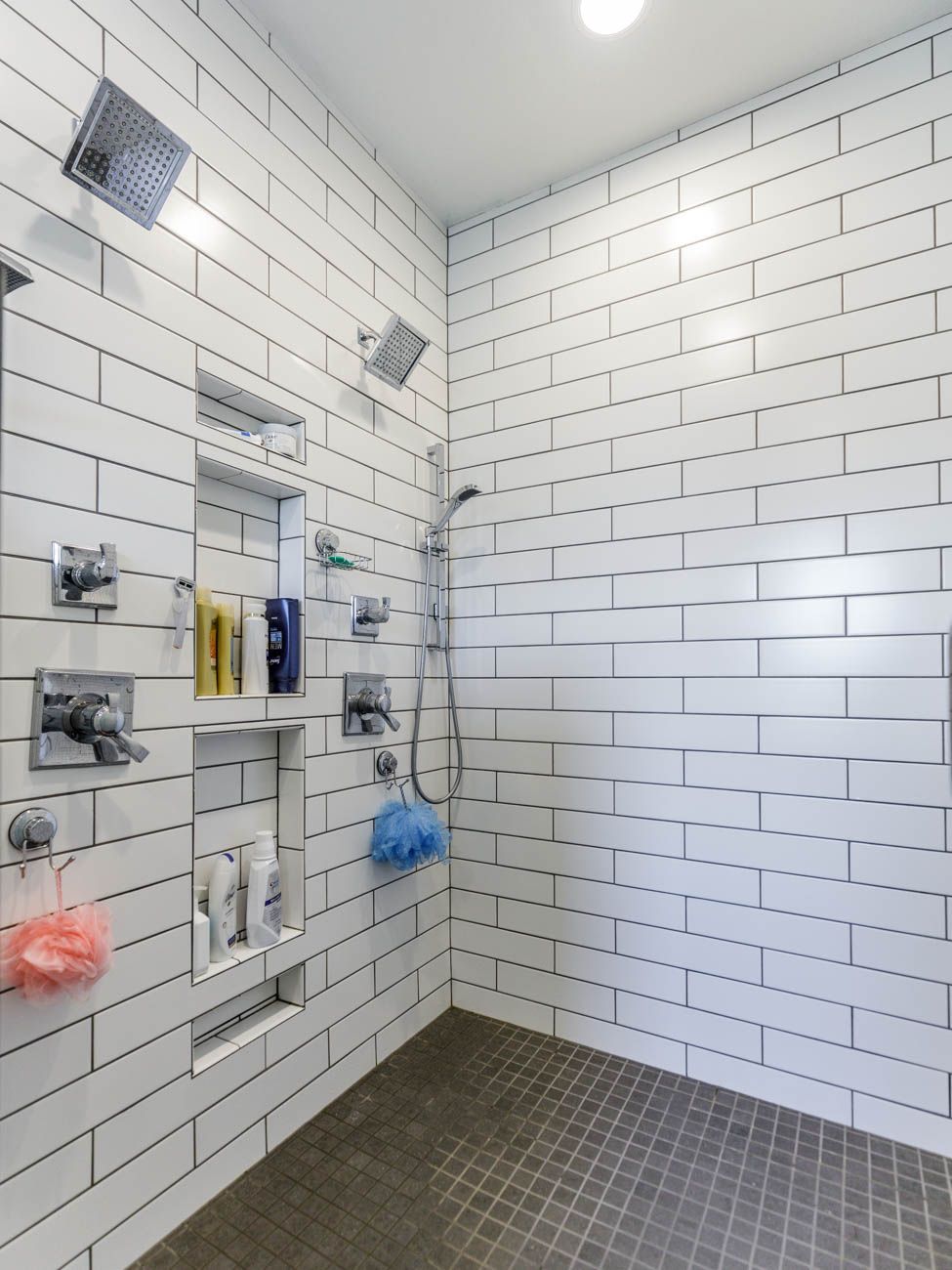 A bathroom with white brick walls and a walk in shower