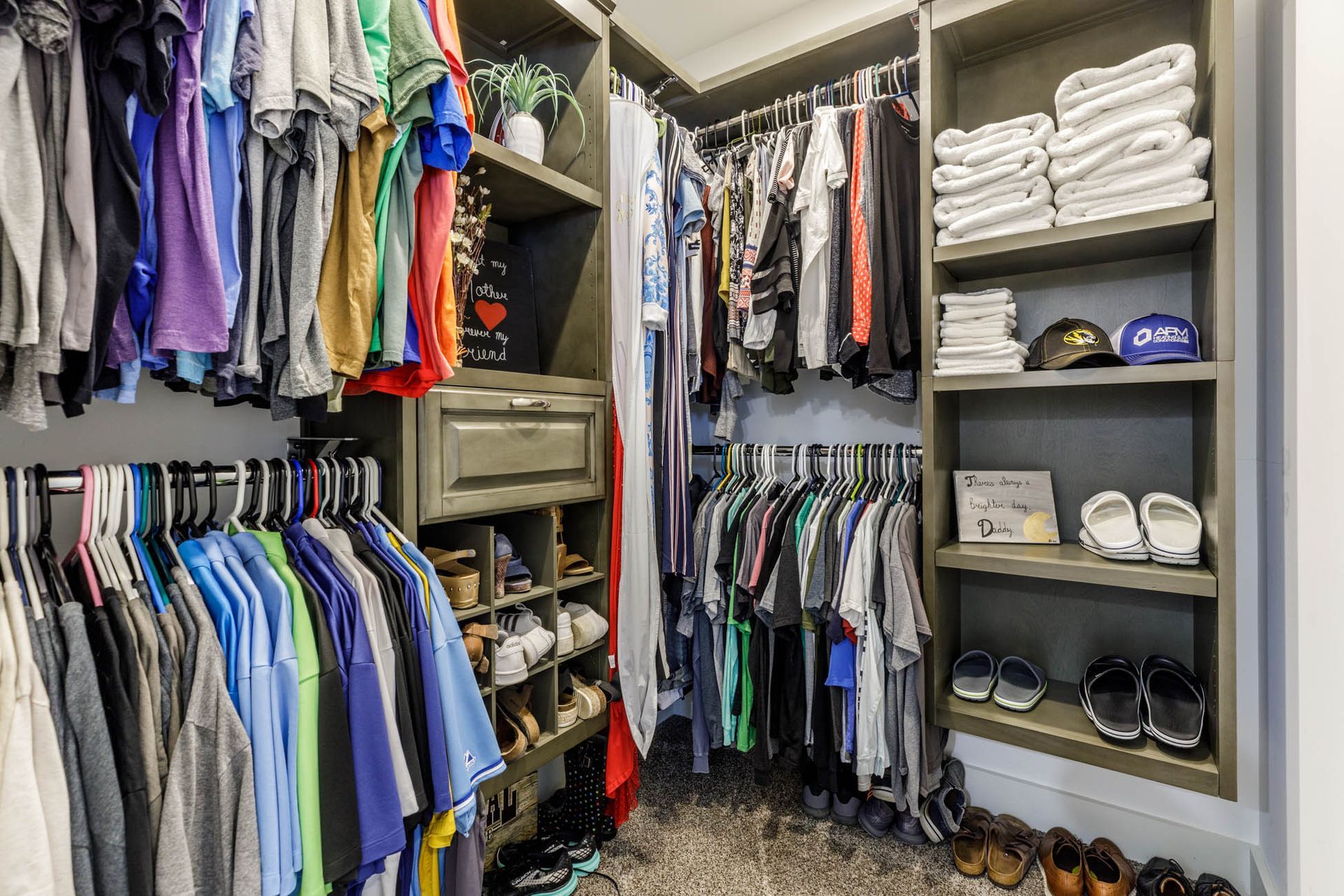 A walk in closet filled with lots of clothes and shoes