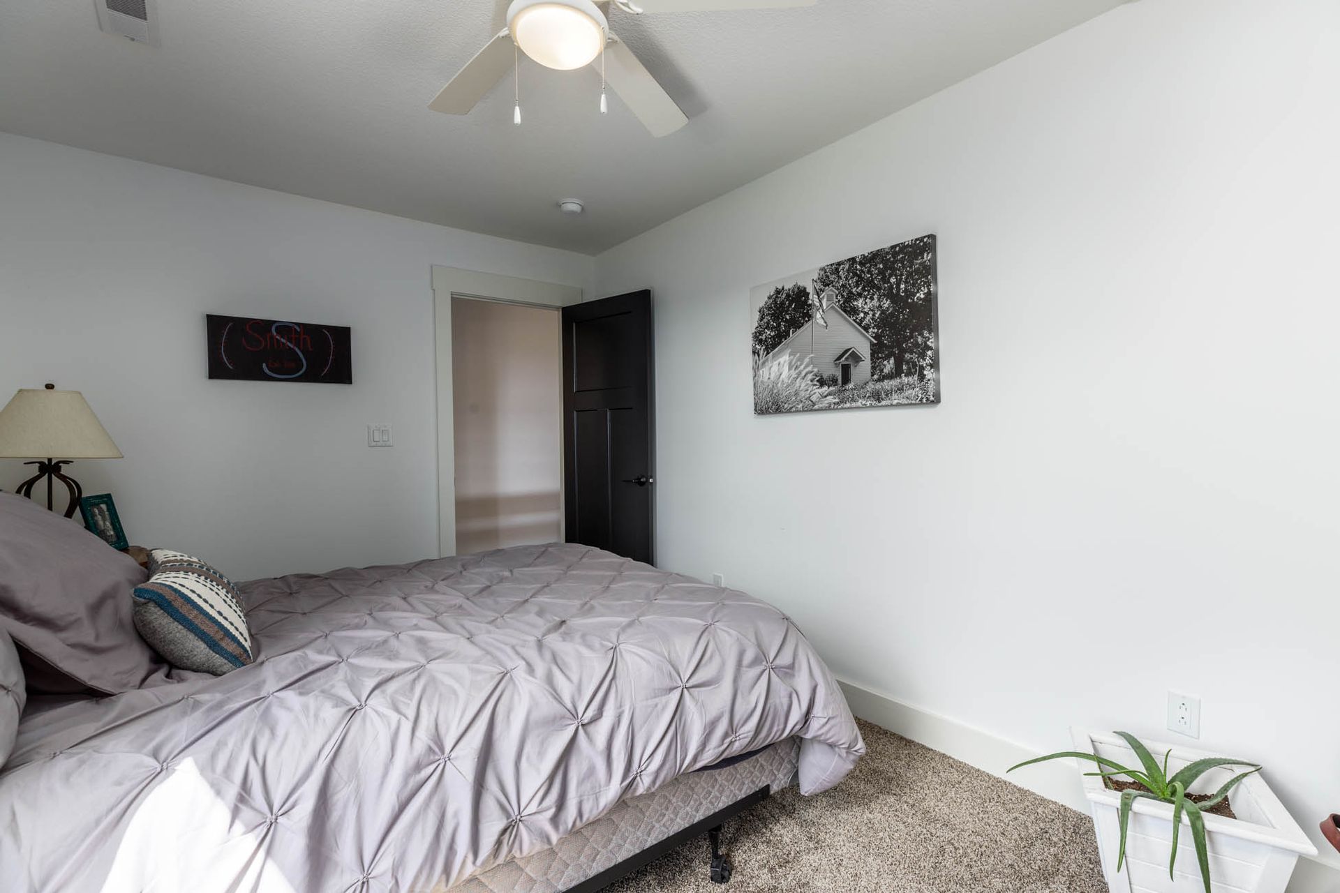 A bedroom with a bed and a ceiling fan