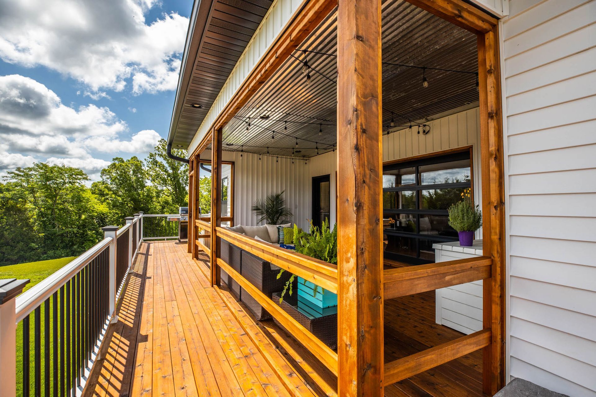 A large wooden deck is sitting on top of a white house