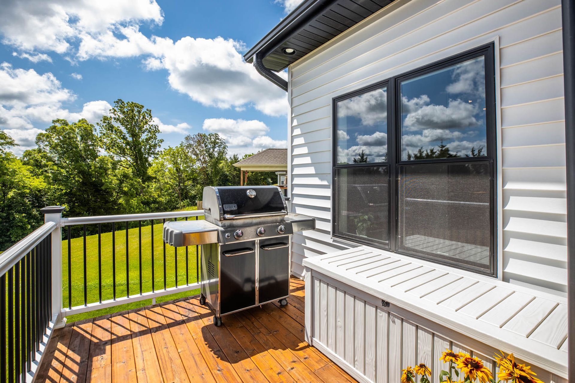 There is a grill on the deck of a house
