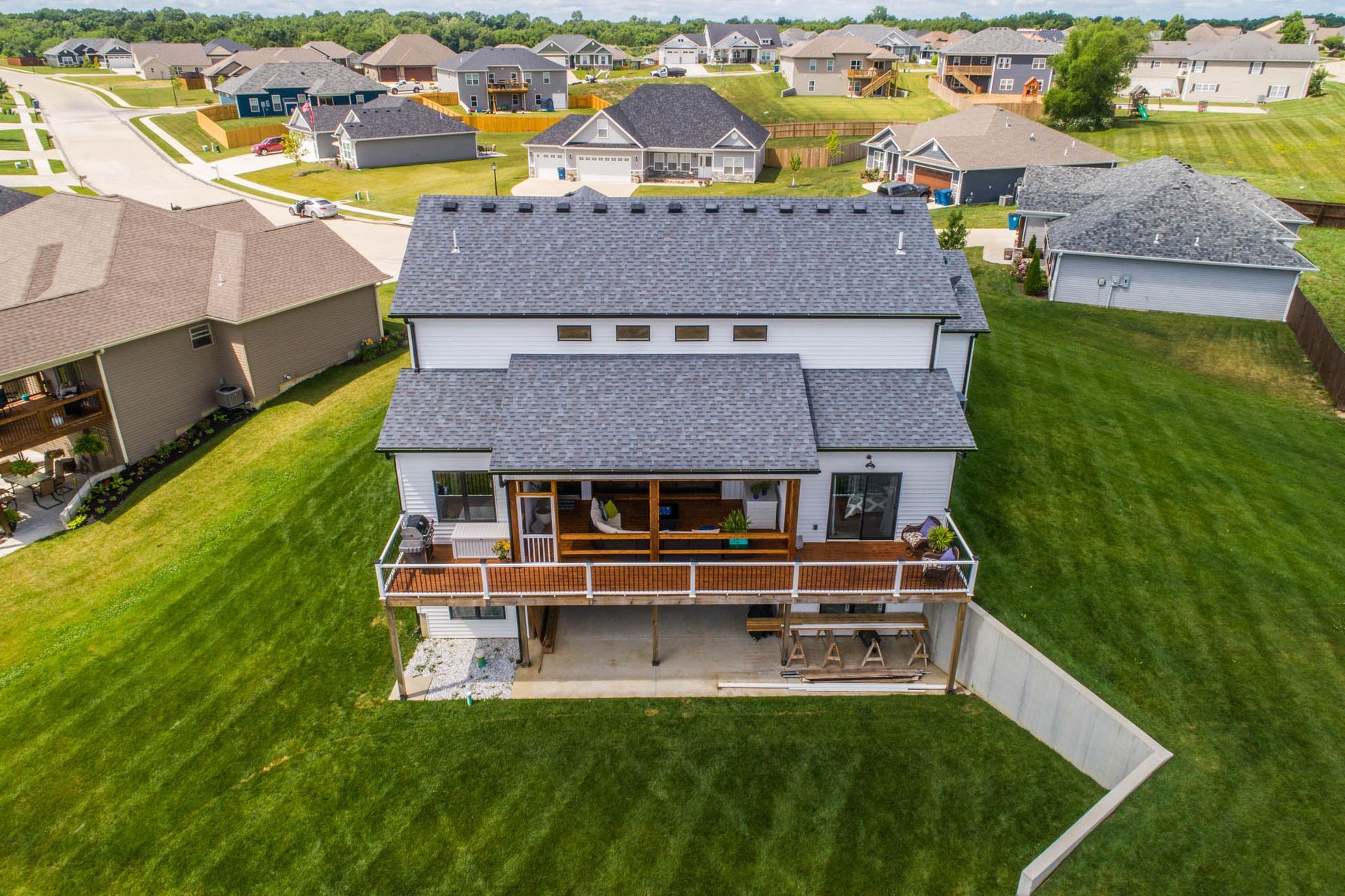 An aerial view of a house with a large deck in a residential area