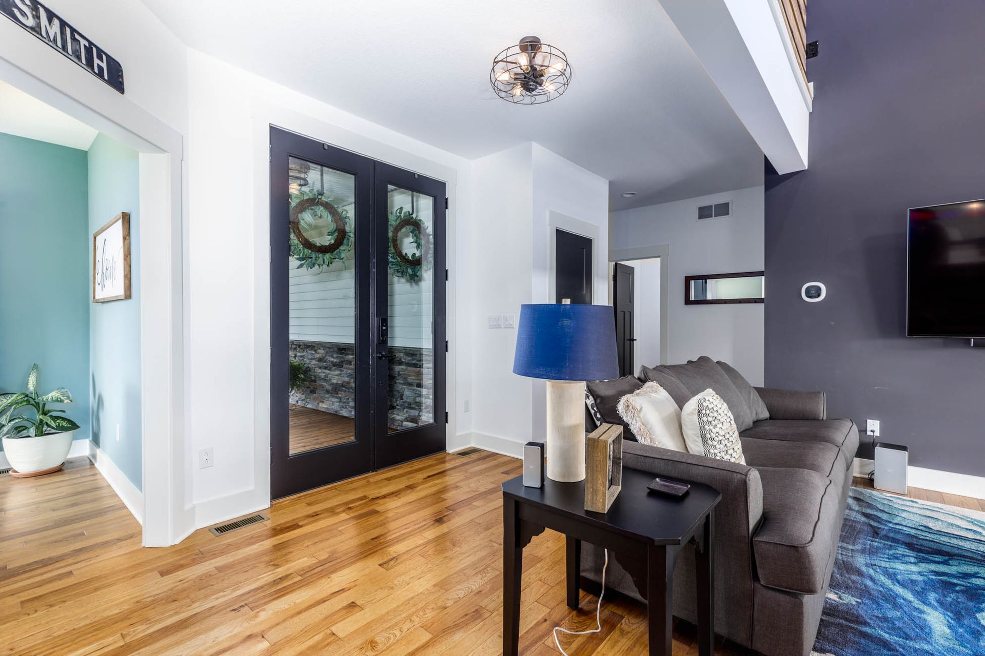 A living room with a couch, table, lamp, and television