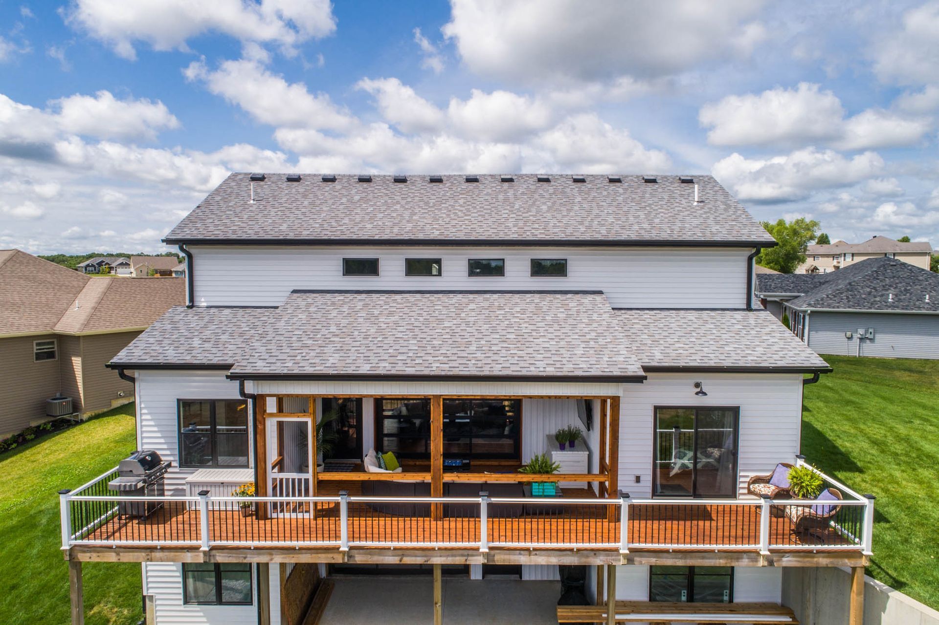 An aerial view of a large white house with a large deck