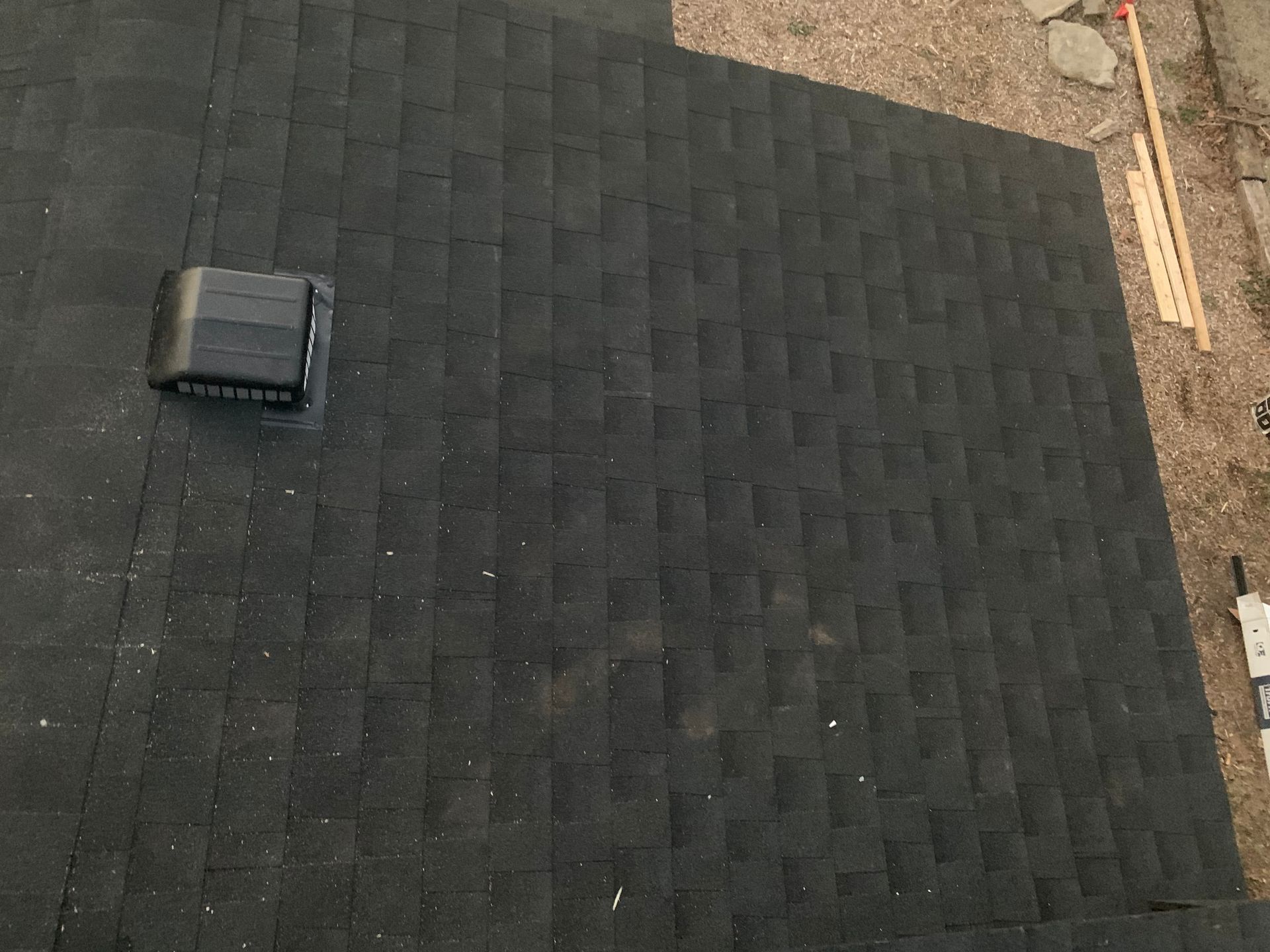 Black shingled roof with a small vent or skylight near the left side