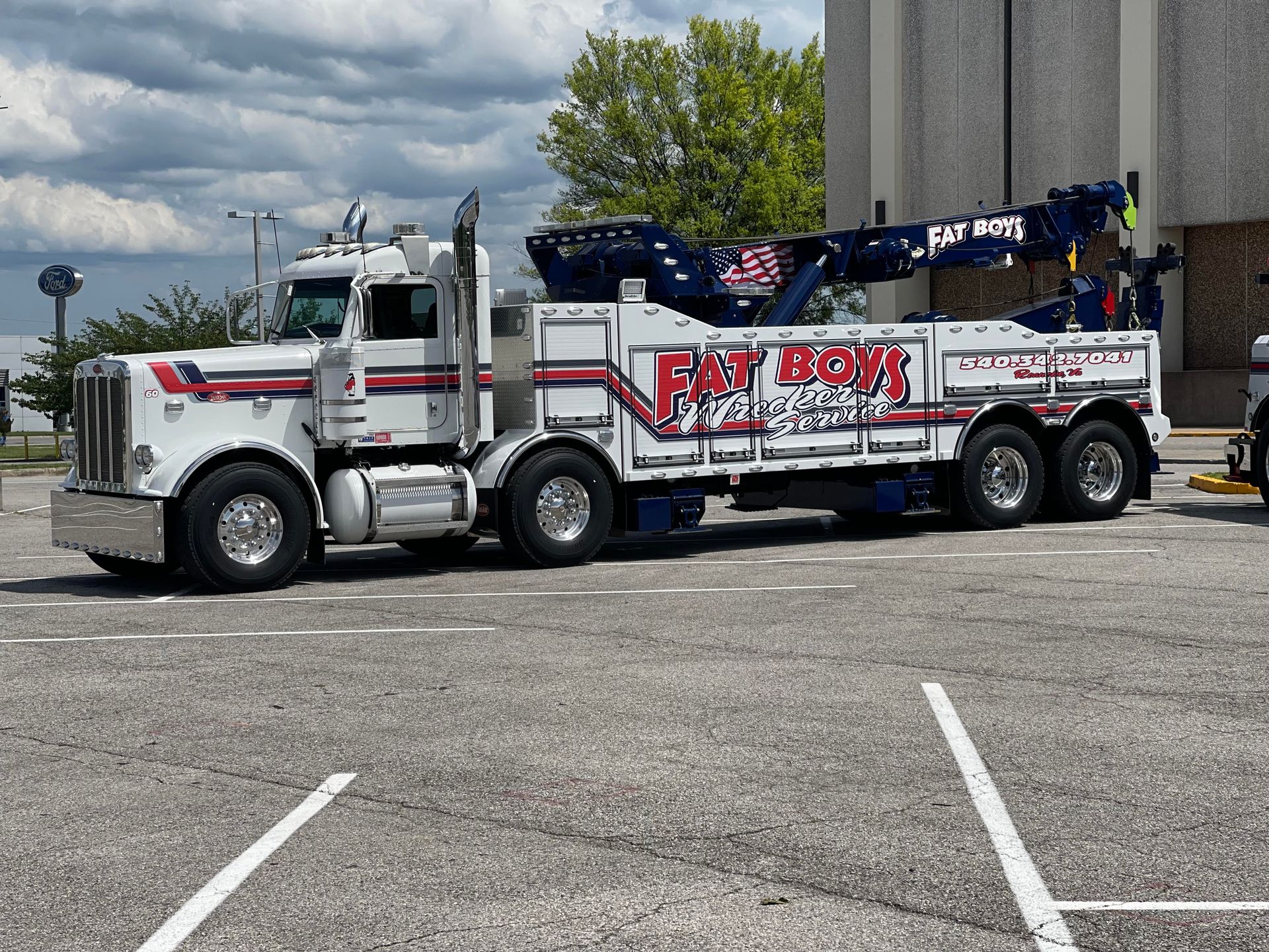 A white tow truck is parked in a parking lot