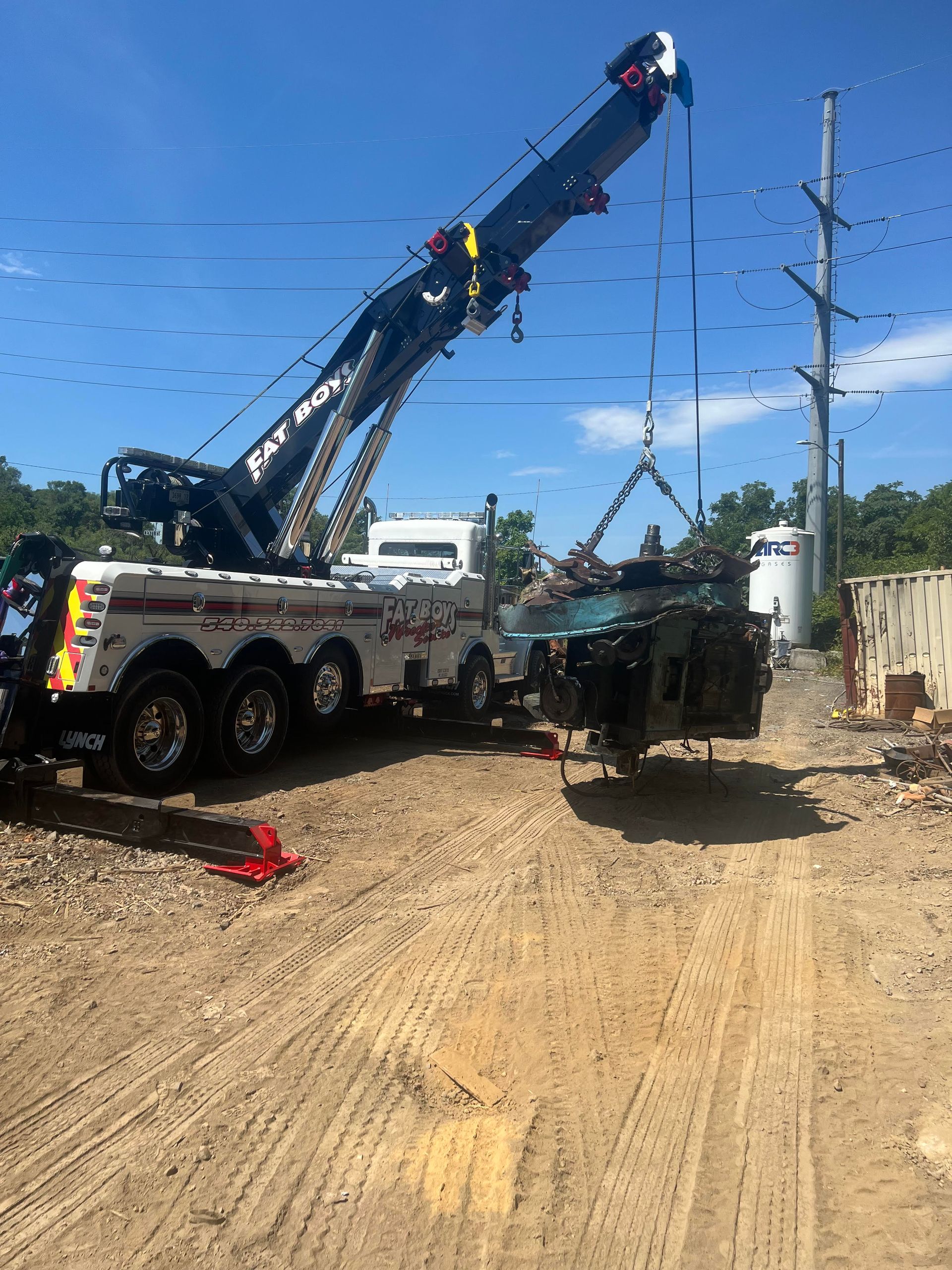 A tow truck with a crane attached to it is towing a vehicle.