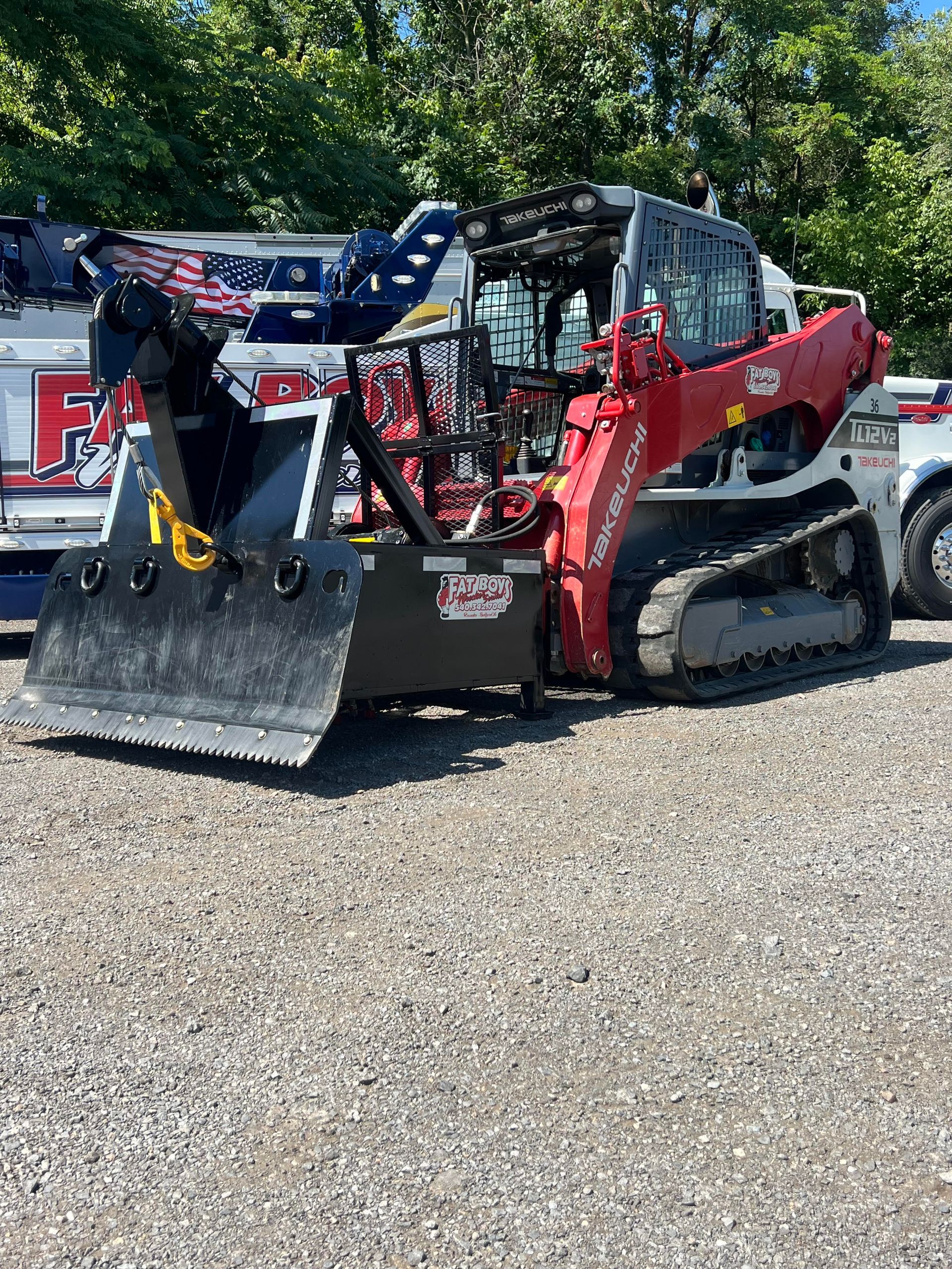 A red and white bulldozer is parked in a gravel lot.