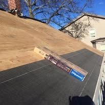 A roof undergoing repair, showing plywood decking and a partial layer of black roofing underlayment with a shingle pack.