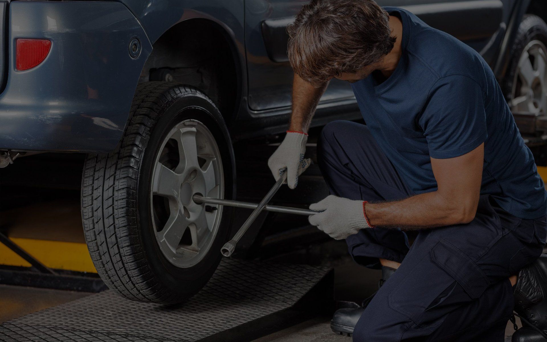 Mechanic servicing a tire with a lug wrench at Sacco's Auto Repair